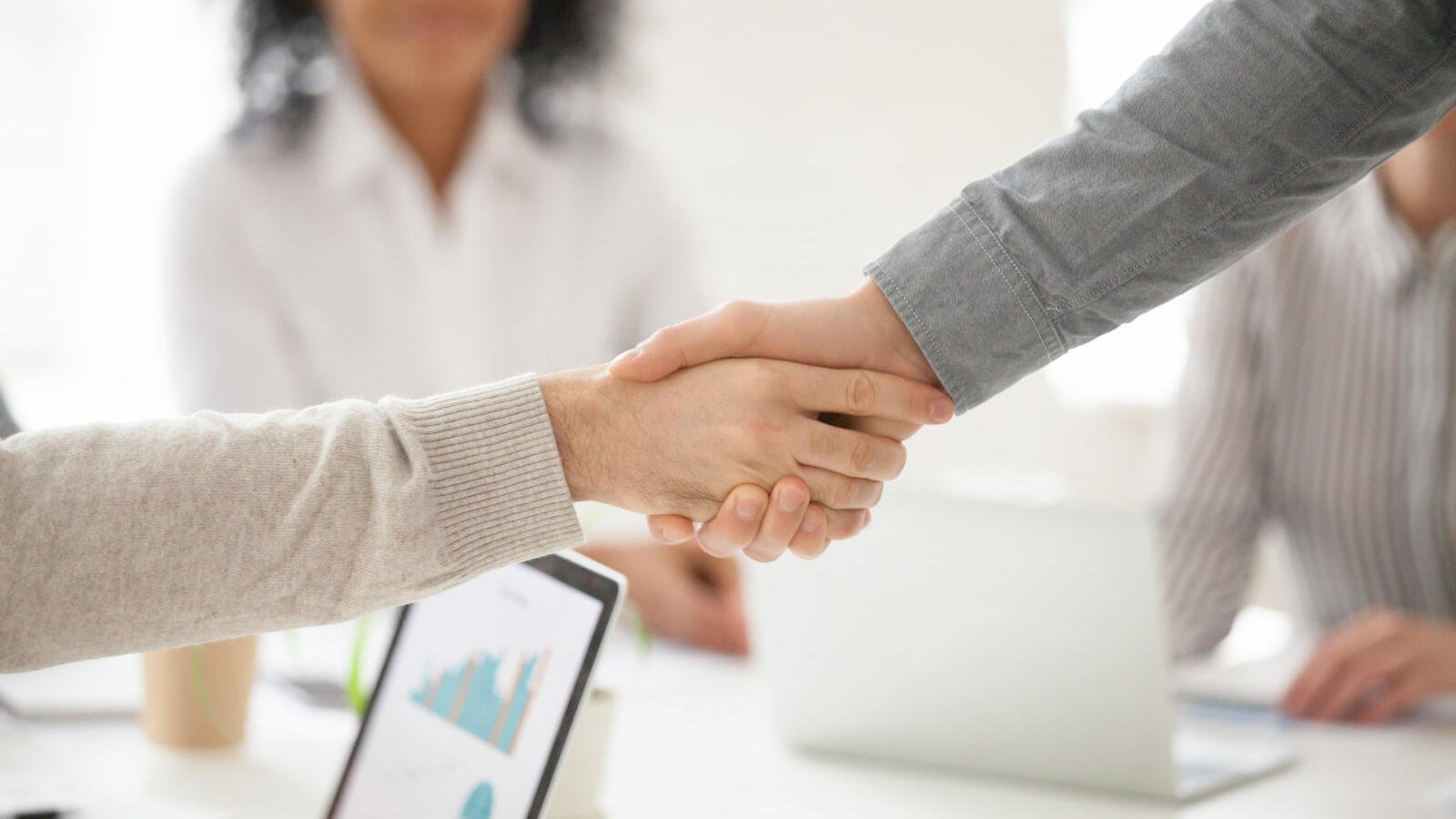 business partners handshaking at group meeting making project investment closeup